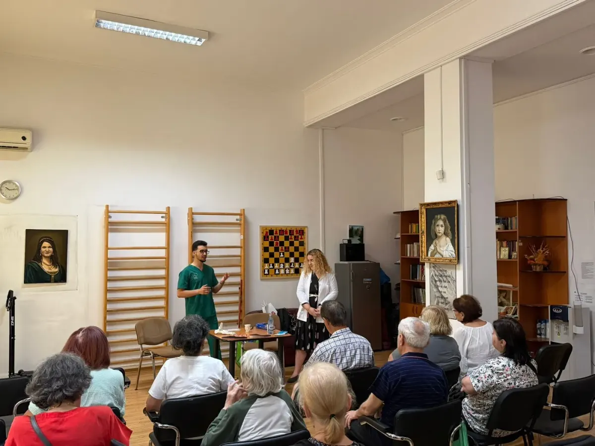 Voluntari discutând despre îngrijirea picioarelor cu vârstnici la Centrul de Asistență Comunitară Basarabia din București