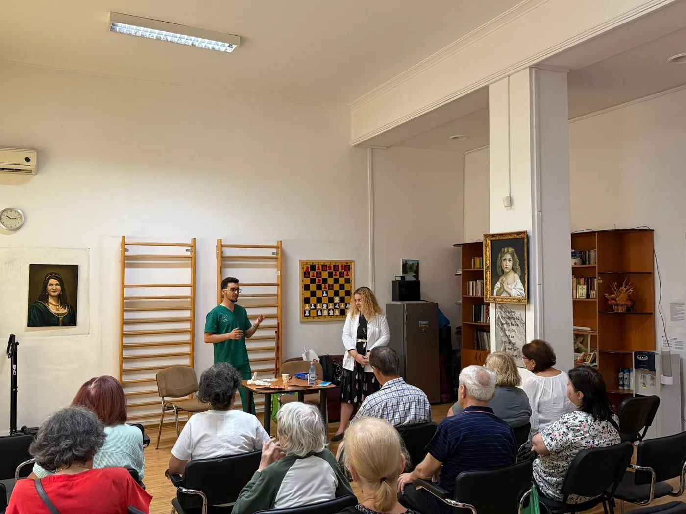 Voluntari discutând despre îngrijirea picioarelor cu vârstnici la Centrul Basarabia din București