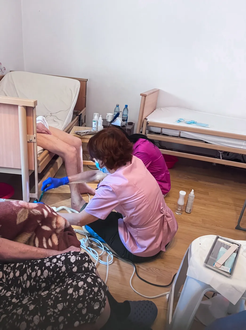 Voluntari ai Asociației Proiecte cu Impact oferind îngrijire podologică unui rezident la Căminul de bătrâni Gherghiței, a doua vizită